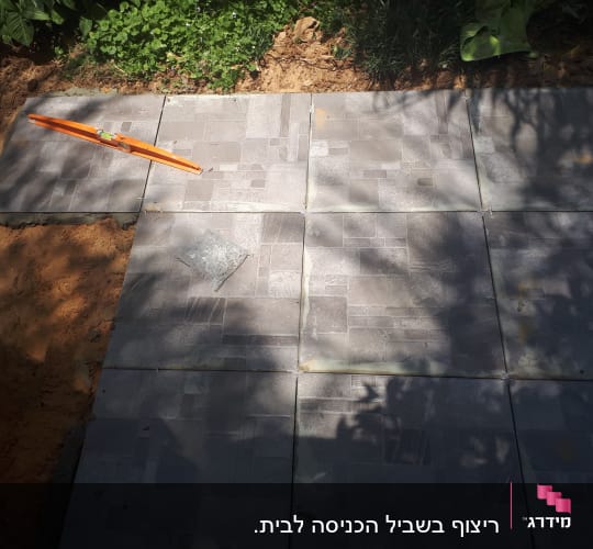 ריצוף חוץ עם פלס כתום על אריחים אפורים